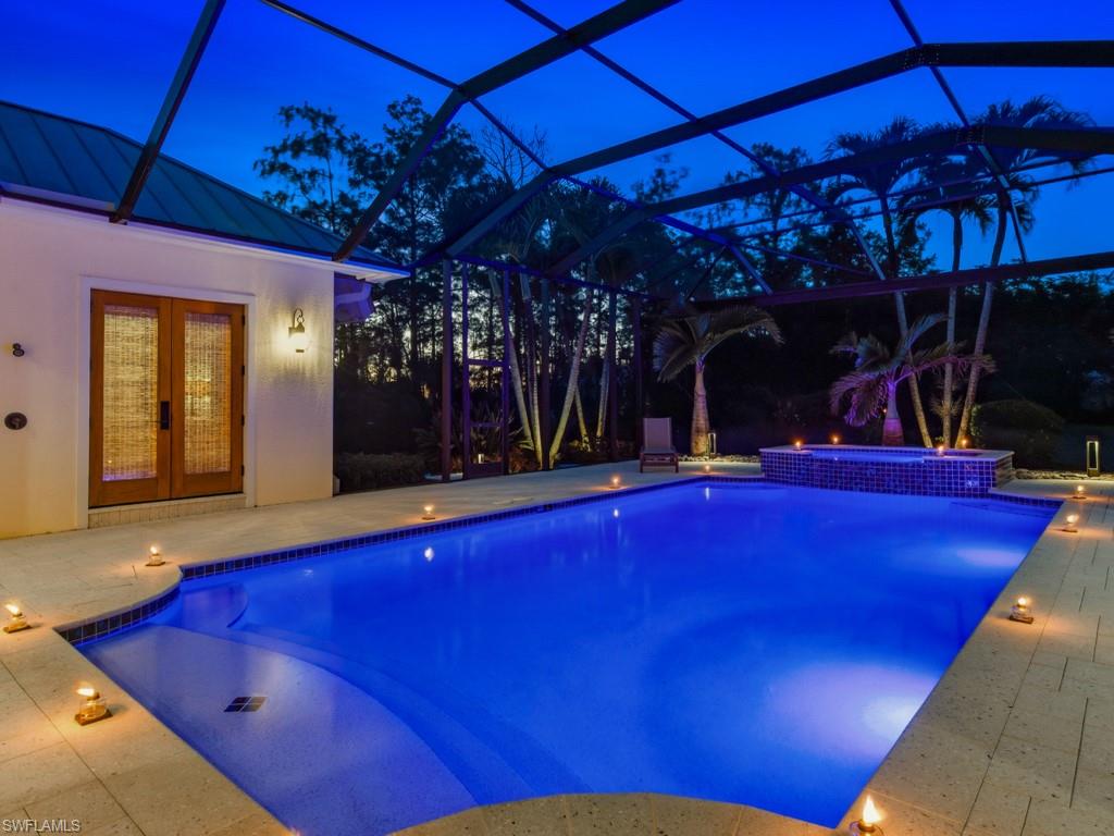 7051 Hunters Road Naples, FL 34109 - Photo 38 of 49 a view of swimming pool with a table and chairs under an umbrella