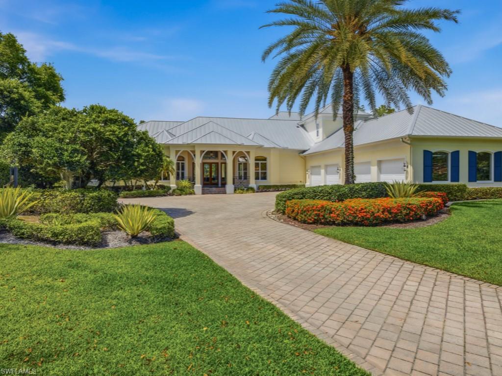 7051 Hunters Road Naples, FL 34109 - Photo 48 of 49 a front view of a house with a garden and trees