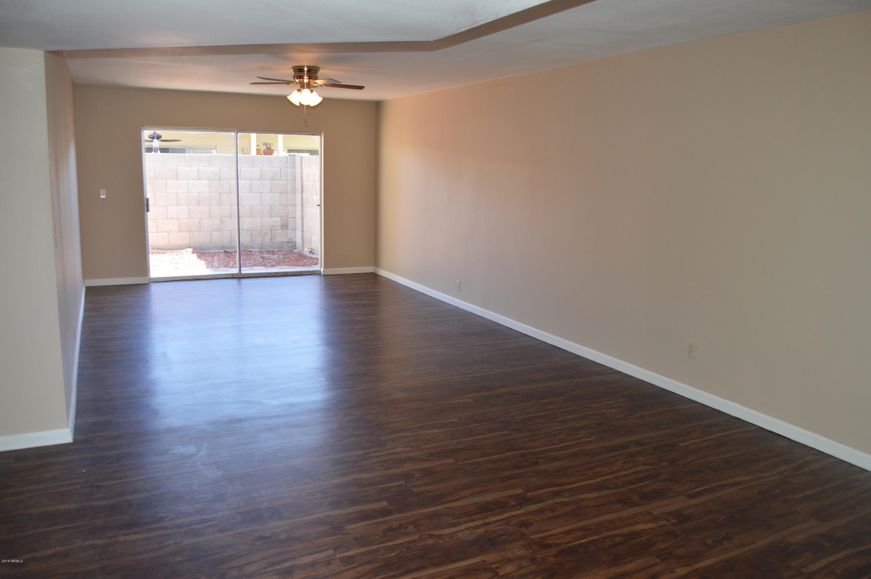 3029 West Redfield Road Phoenix, AZ 85053 - Photo 4 of 21 a view of an empty room with wooden floor and a window