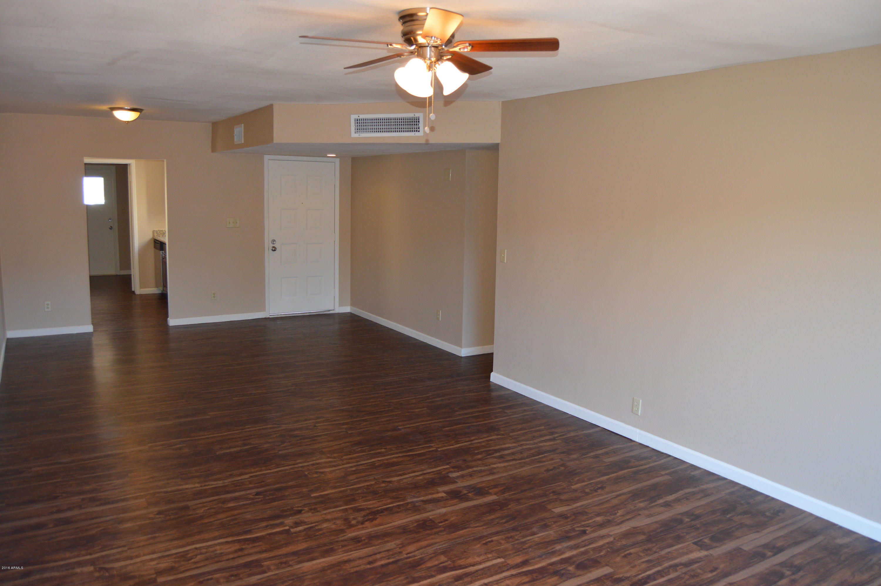 3029 West Redfield Road Phoenix, AZ 85053 - Photo 5 of 21 a view of an empty room with wooden floor and a ceiling fan