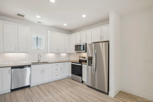 a kitchen with stainless steel appliances granite countertop a refrigerator sink and microwave