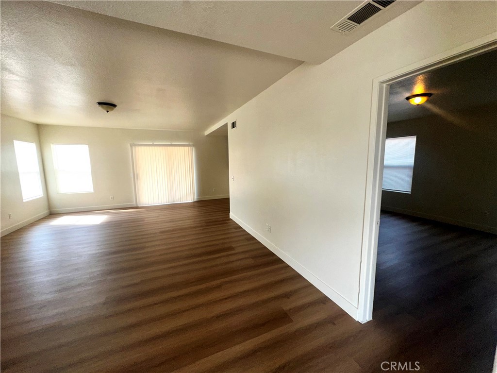 14413 Stivers Road Victorville, CA 92394 - Photo 4 of 17 a view of an empty room with wooden floor and a window