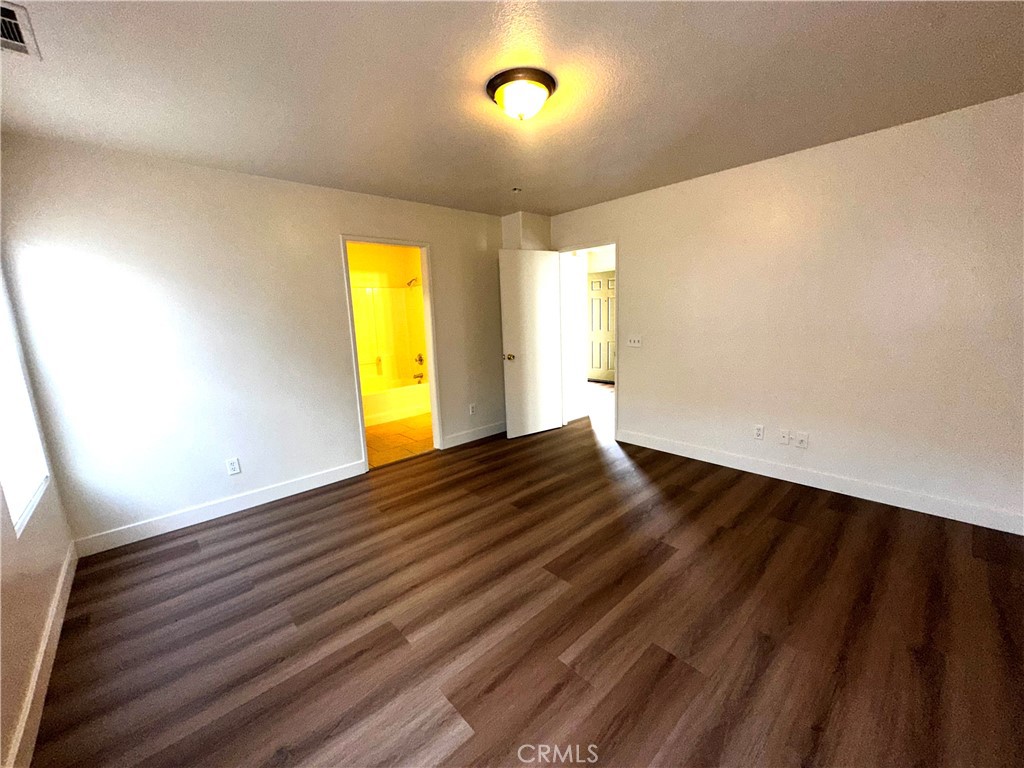 14413 Stivers Road Victorville, CA 92394 - Photo 8 of 17 a view of empty room with wooden floor and fan