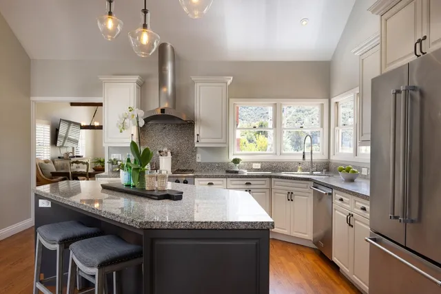 a kitchen with granite countertop a sink stove and refrigerator