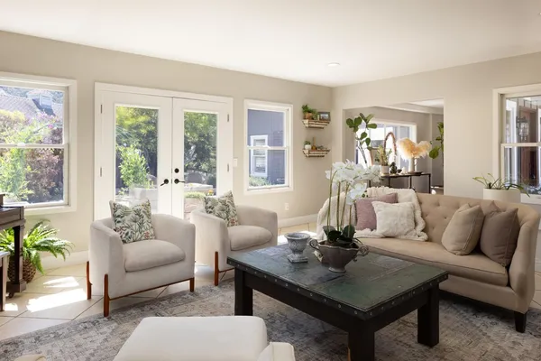 a living room with furniture a table and a large window