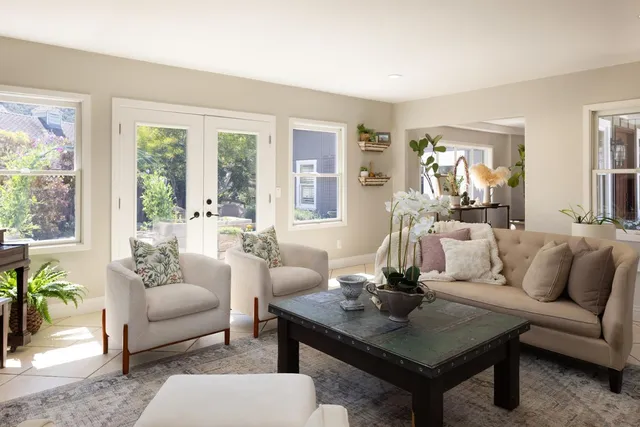 a living room with furniture a table and a large window