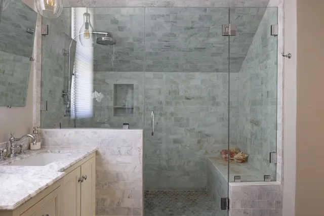 a bathroom with a granite countertop shower a sink and vanity