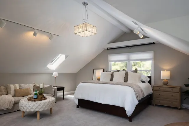 a bedroom with bed and a chandelier