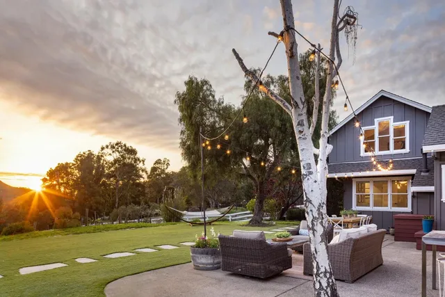 a view of a house with backyard sitting area and garden