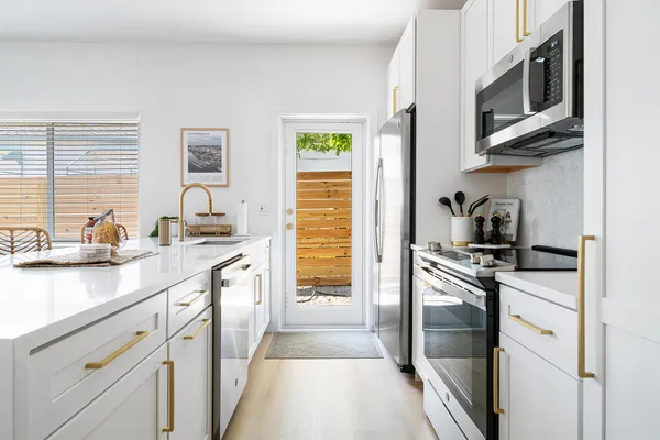 a kitchen with stainless steel appliances granite countertop a sink and a stove