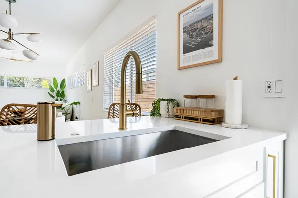 a kitchen with stainless steel appliances a sink a counter top space and living room