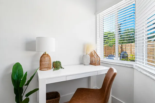 a dining room with furniture and a potted plant