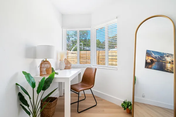 a view of a workspace with furniture and a window