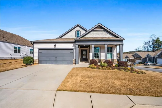 a front view of a house with yard outdoor seating and garage