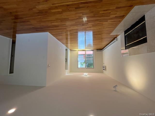 25 South Norwood Road, Unit LEFT Port Washington, NY 11050 - Photo 3 of 19 a view of an empty room with wooden floor and a fireplace