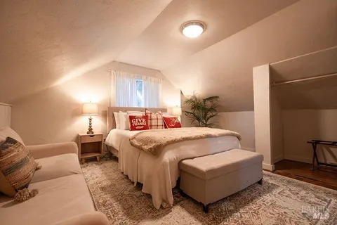 a bedroom with a bed lamp and a dresser