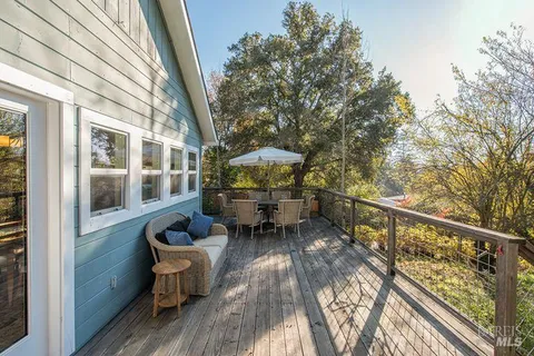 a balcony with wooden floor and outdoor seating