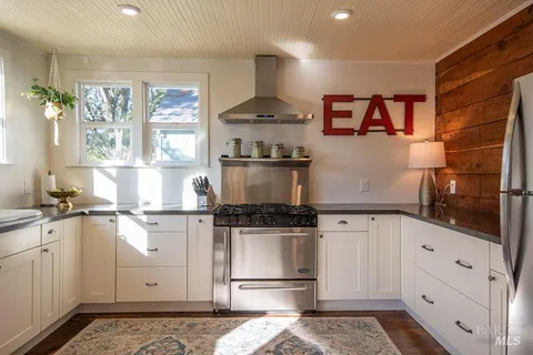 a kitchen with stainless steel appliances granite countertop a stove a sink and a refrigerator