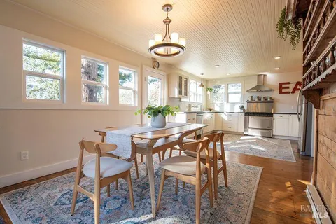 a view of a dining room with furniture and a chandelier
