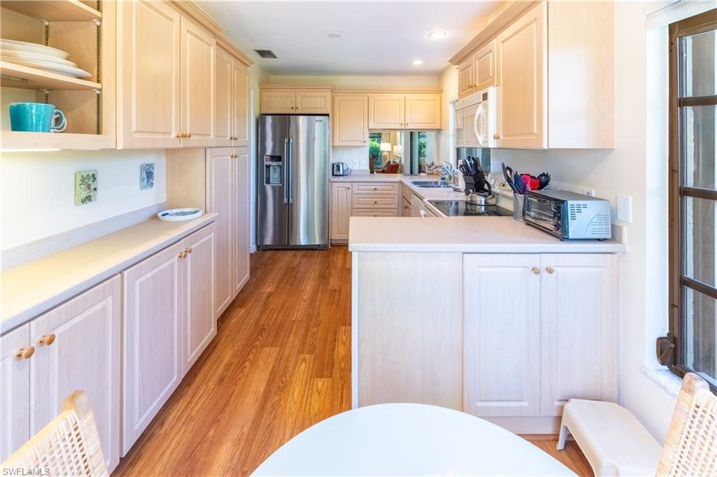 522 Beachwalk Circle Naples, FL 34108 - Photo 11 of 34 a kitchen with stainless steel appliances a sink and a refrigerator