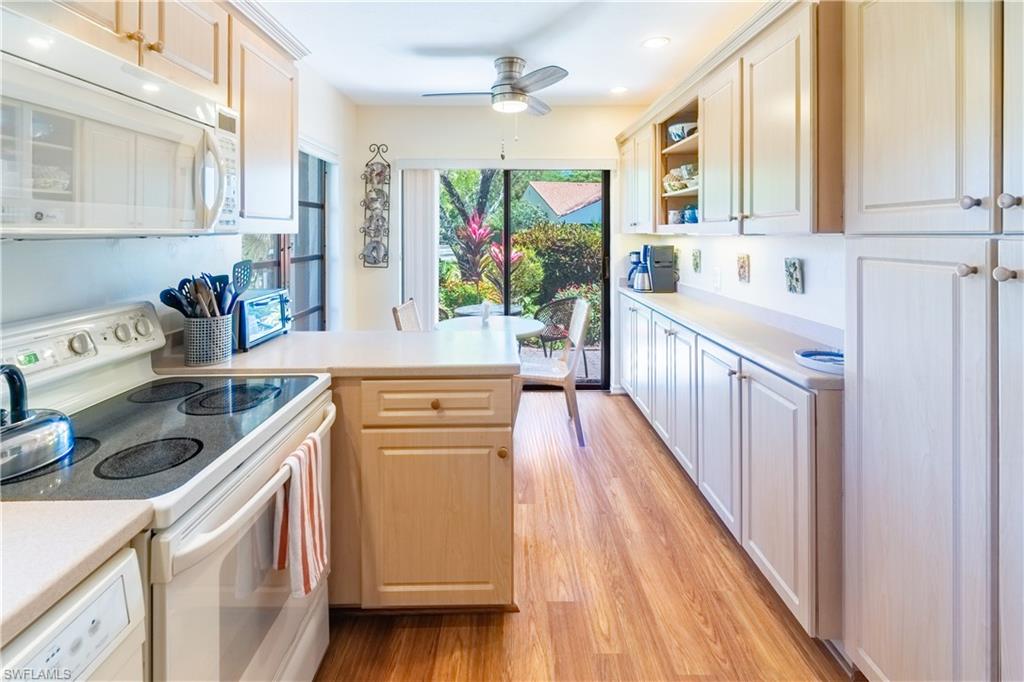 522 Beachwalk Circle Naples, FL 34108 - Photo 14 of 34 a kitchen with stainless steel appliances a stove a sink and a refrigerator