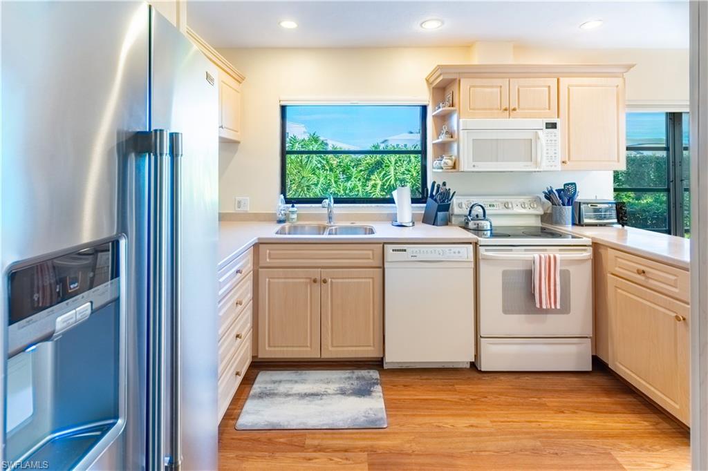 522 Beachwalk Circle Naples, FL 34108 - Photo 15 of 34 a kitchen with a sink stove and cabinets