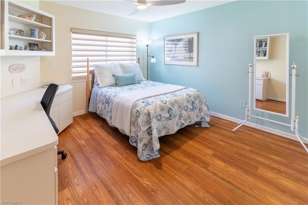 522 Beachwalk Circle Naples, FL 34108 - Photo 17 of 34 a bedroom with a bed and wooden floor