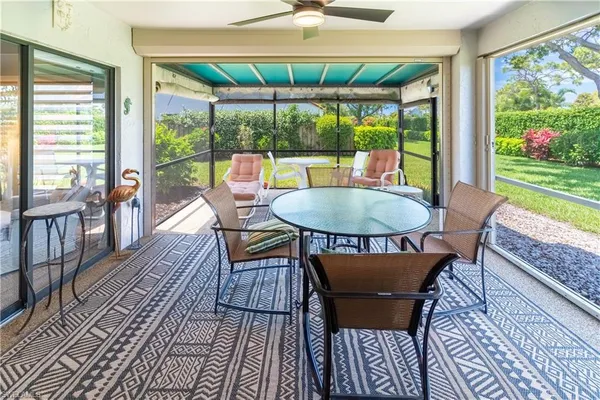 a dining room with furniture a rug and a floor to ceiling window