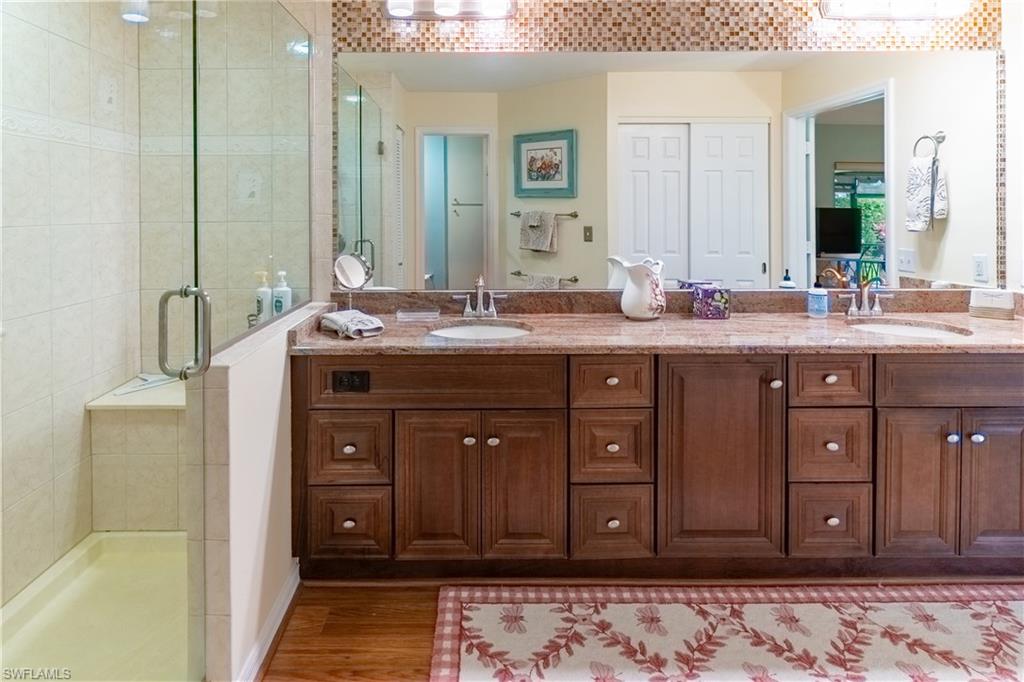 522 Beachwalk Circle Naples, FL 34108 - Photo 20 of 34 a spacious bathroom with a granite countertop sink and a mirror