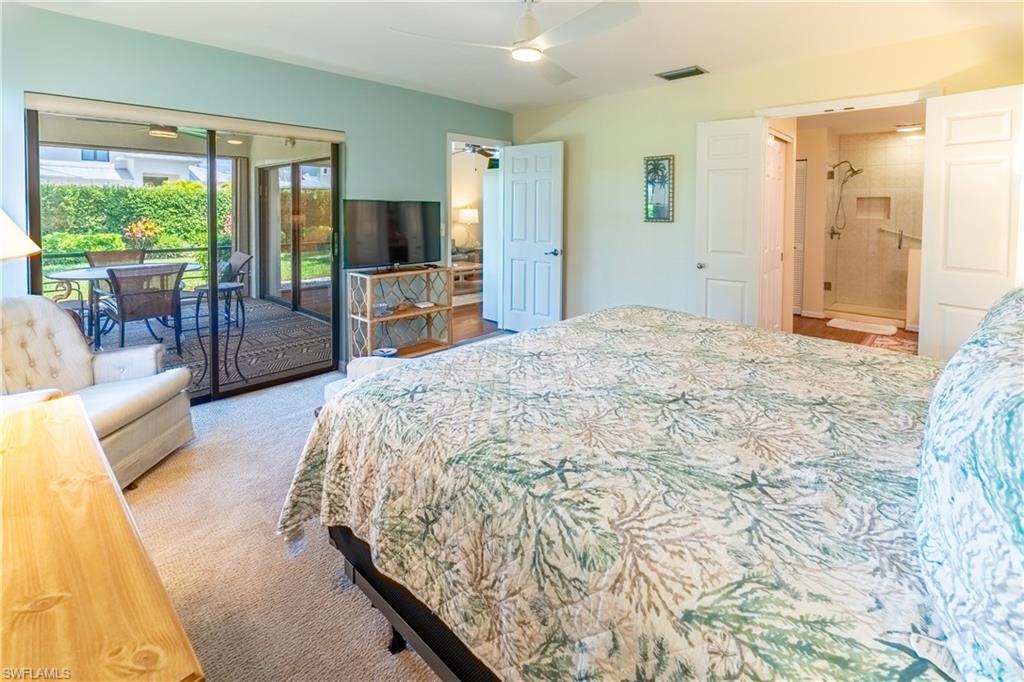 522 Beachwalk Circle Naples, FL 34108 - Photo 23 of 34 a spacious bedroom with a large bed and a flat tv screen