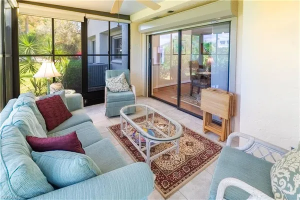 a living room with furniture and a floor to ceiling window