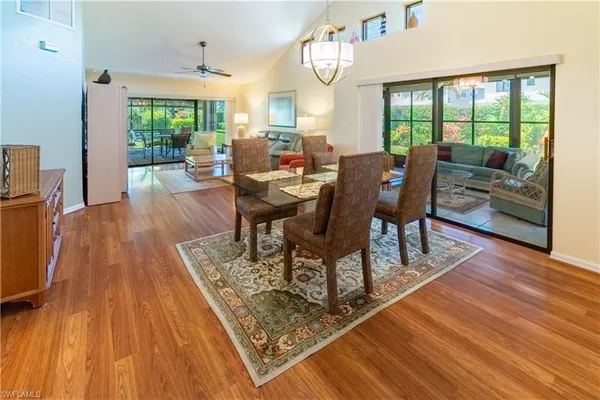 a living room with furniture a large window and wooden floor