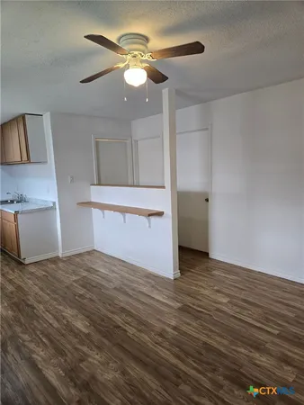 a view of a kitchen with wooden floor and a ceiling fan