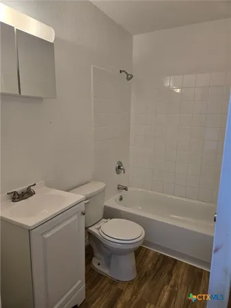 a white toilet and tub sitting next to a bathroom sink