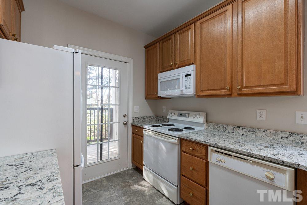 7022 Sandy Forks Road, Unit 201 Raleigh, NC 27615 - Photo 12 of 30 a kitchen with stainless steel appliances granite countertop a stove a sink and a microwave