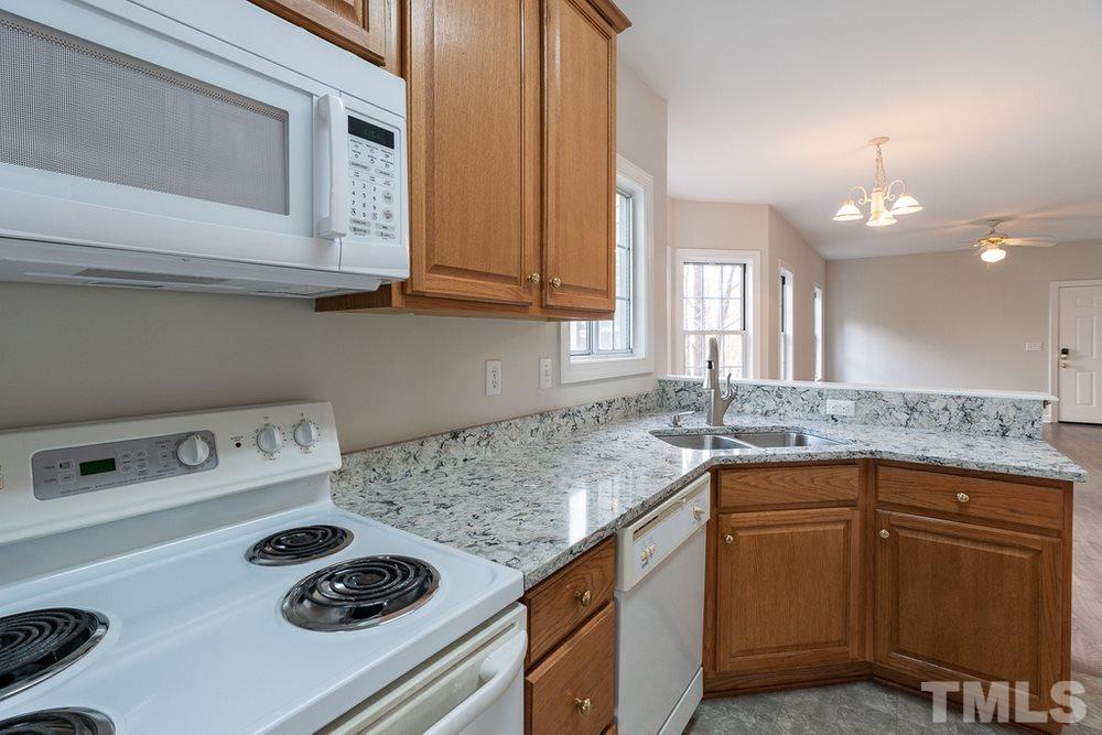 7022 Sandy Forks Road, Unit 201 Raleigh, NC 27615 - Photo 15 of 30 a kitchen with kitchen island a sink stove and cabinets