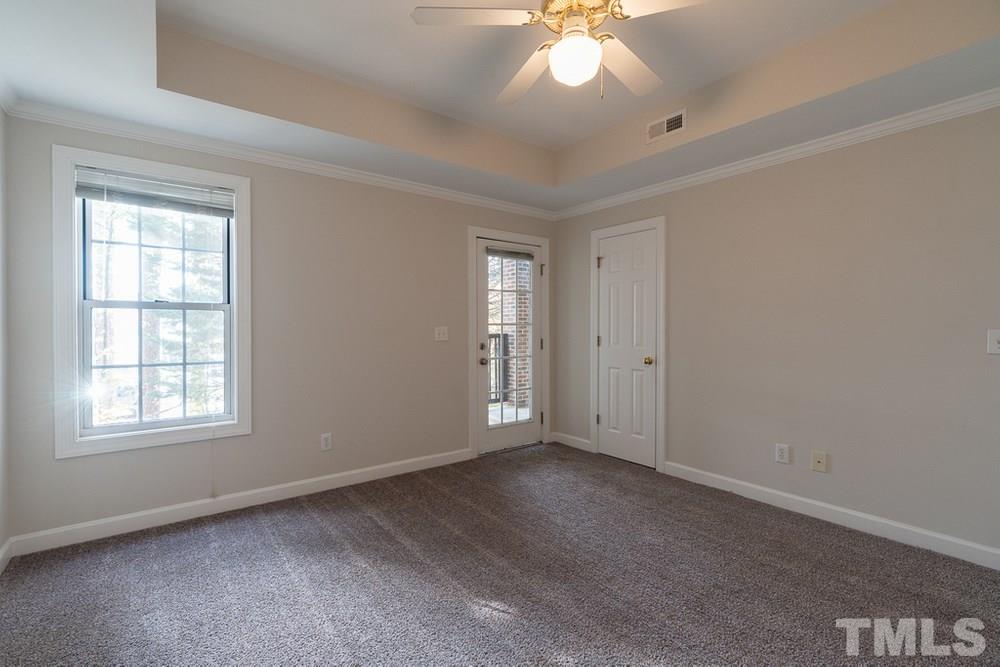 7022 Sandy Forks Road, Unit 201 Raleigh, NC 27615 - Photo 19 of 30 an empty room with a chandelier fan and windows