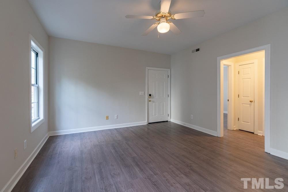 7022 Sandy Forks Road, Unit 201 Raleigh, NC 27615 - Photo 5 of 30 an empty room with wooden floor and windows
