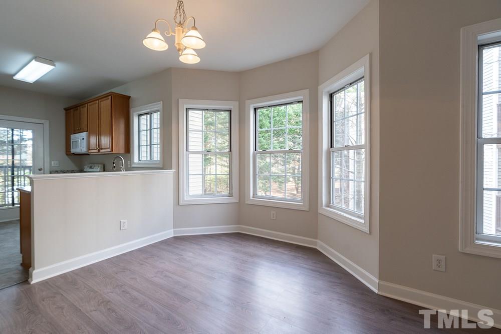 7022 Sandy Forks Road, Unit 201 Raleigh, NC 27615 - Photo 6 of 30 a view of an empty room with wooden floor and a window