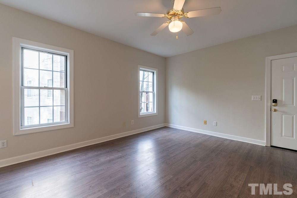 7022 Sandy Forks Road, Unit 201 Raleigh, NC 27615 - Photo 7 of 30 a view of an empty room with wooden floor and a window