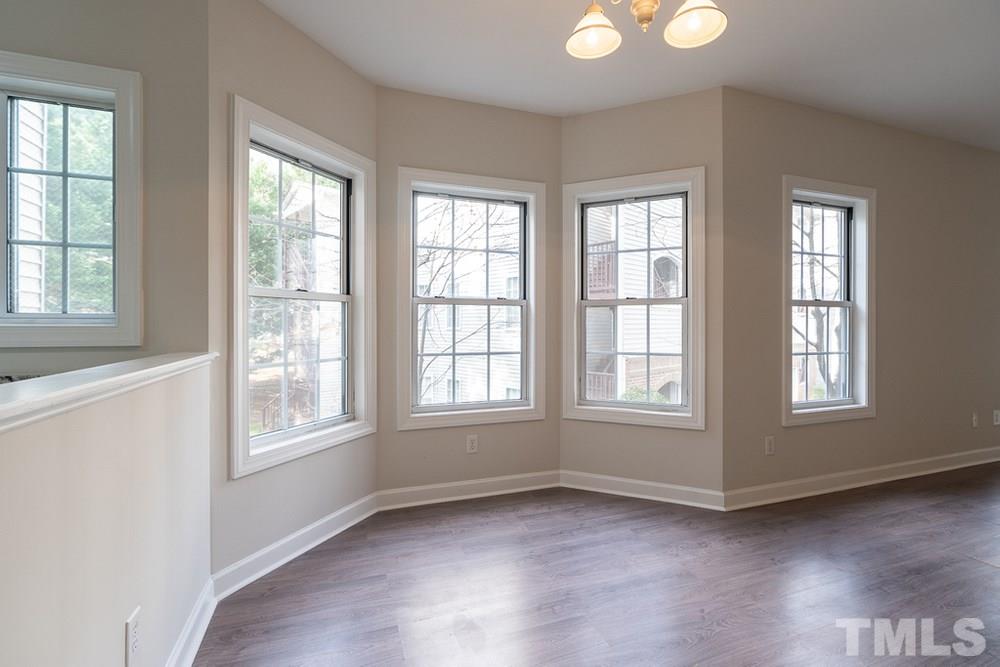 7022 Sandy Forks Road, Unit 201 Raleigh, NC 27615 - Photo 8 of 30 an empty room with wooden floor and windows