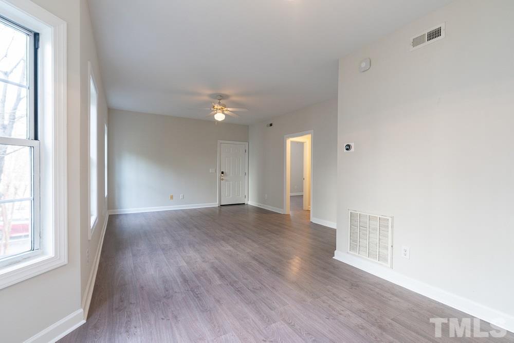7022 Sandy Forks Road, Unit 201 Raleigh, NC 27615 - Photo 10 of 30 a view of an empty room with wooden floor and a window