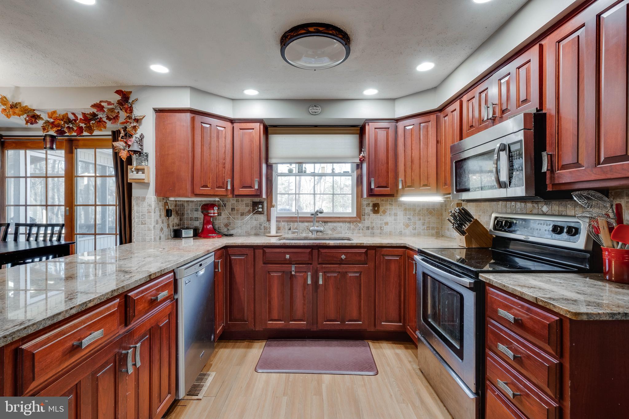 572 Fairview Road Medford, NJ 08055 - Photo 8 of 48 a kitchen with stainless steel appliances granite countertop wooden cabinets a window a sink and a counter space