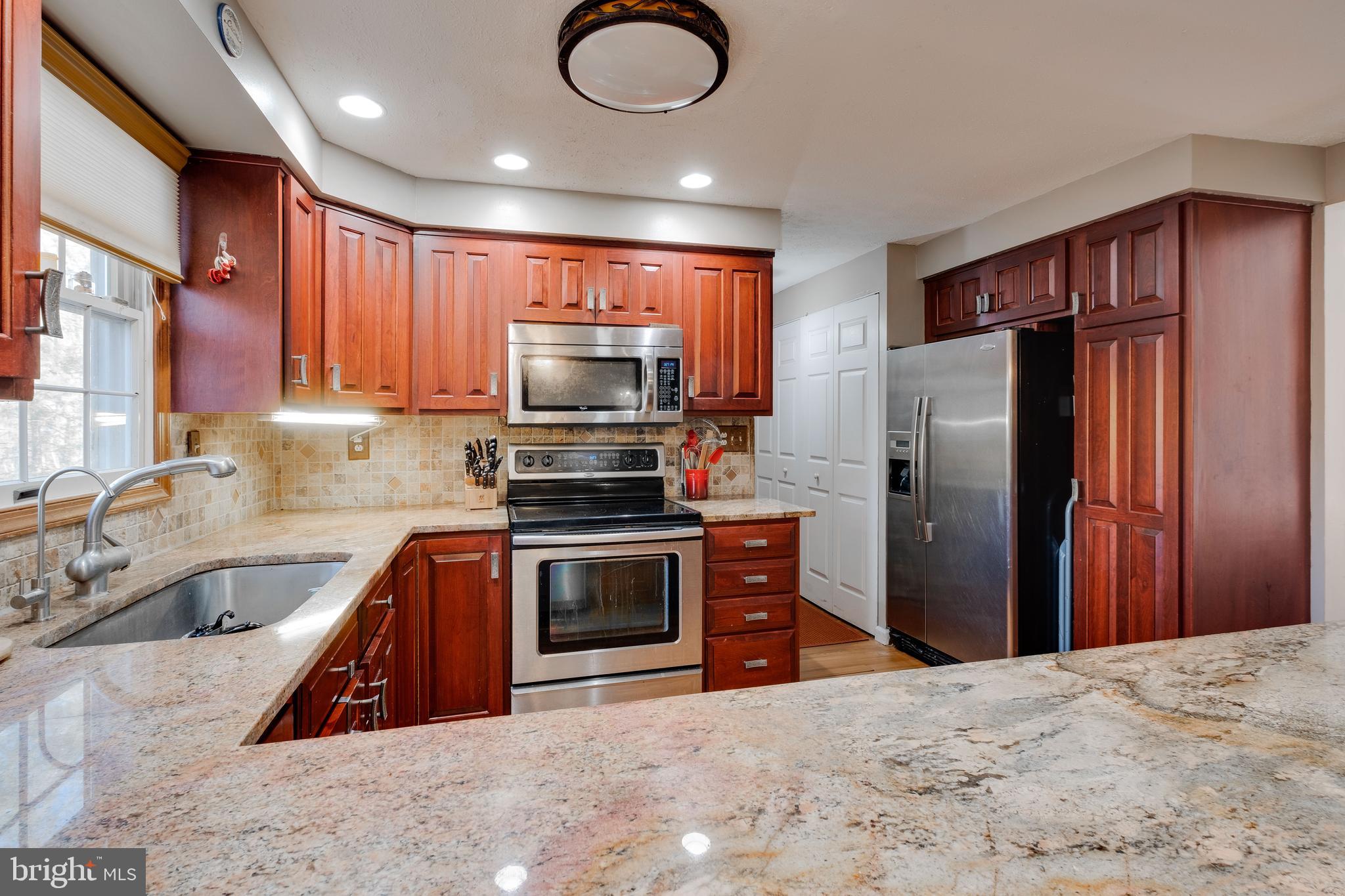 572 Fairview Road Medford, NJ 08055 - Photo 10 of 48 a kitchen with stainless steel appliances granite countertop a refrigerator a stove and a sink with wooden cabinets