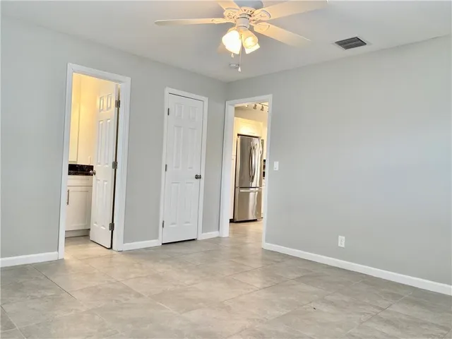 an empty room with fan and entrance