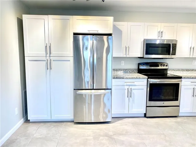 a kitchen with stainless steel appliances a refrigerator sink and microwave