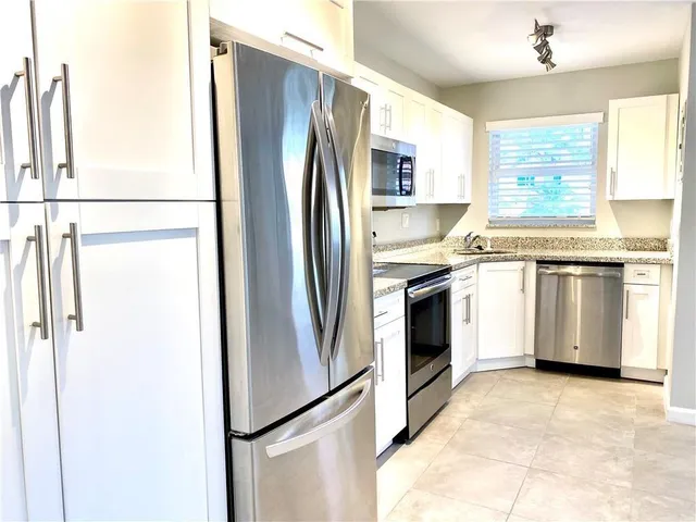 a kitchen with stainless steel appliances a refrigerator sink and cabinets