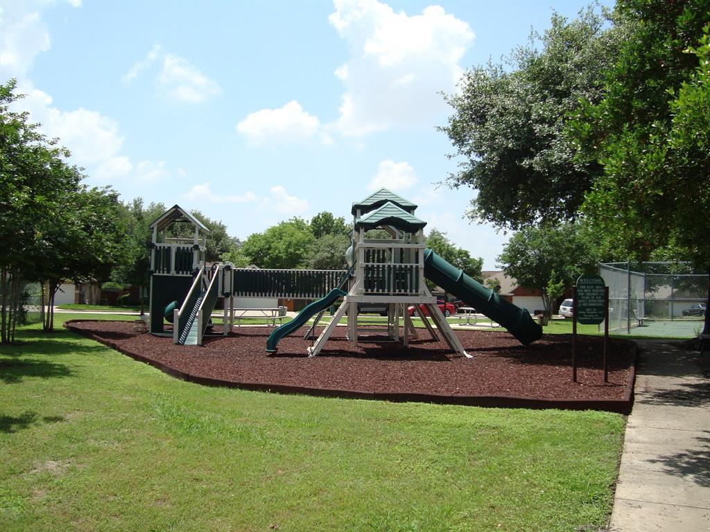 814 Broken Feather Trail Pflugerville, TX 78660 - Photo 20 of 24 A community playground, perfect for recreation, sits beside a paved walkway.