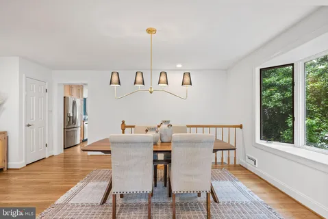 a kitchen with granite countertop a refrigerator a sink and white cabinets