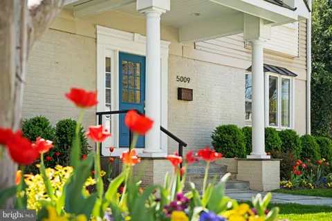 a front view of a house with a yard and potted plants